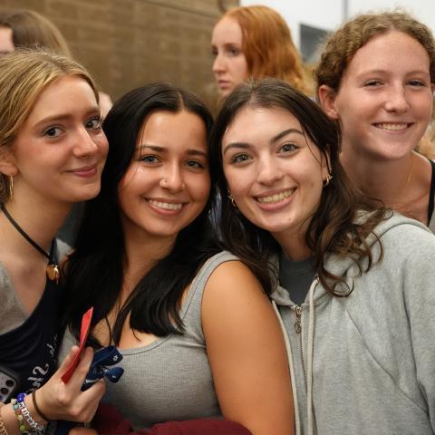 Four students standing together smiling.